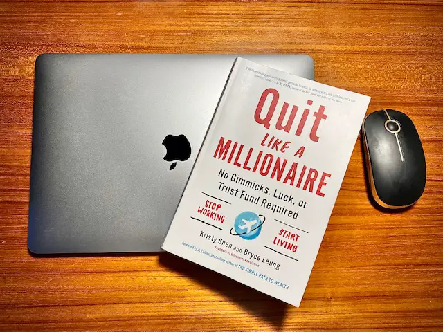 Image of quit like a millionaire book on top of macbook