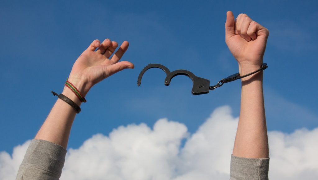 hands being freed from handcuffs